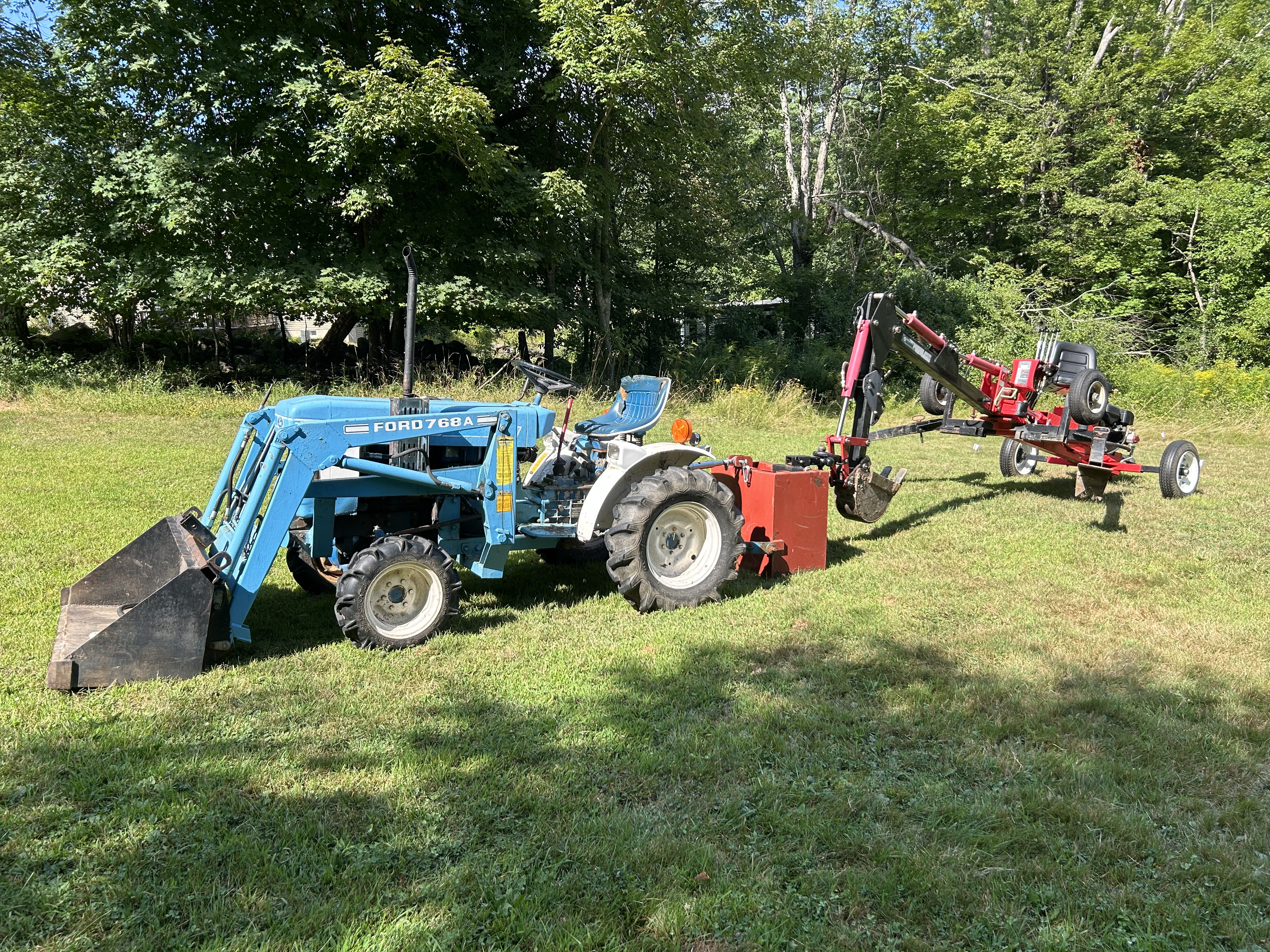 Wide shot of towing a Harbor Freight Backhoe Trencher with a tractor